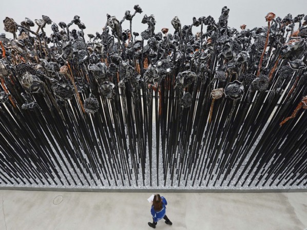 A woman walks in front of the sculpture 'Living together' (2012)in the exhibition 'Re-Generation'. AP Photo/Jens Meyer.