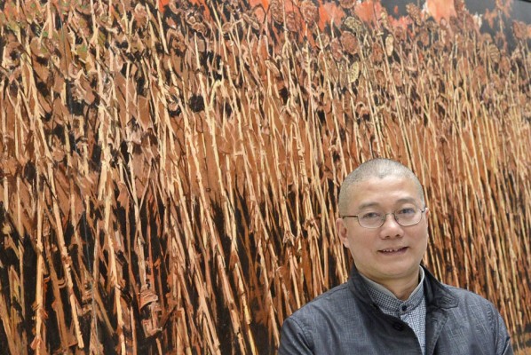 Xu Jiang Stands before his work 'Sunflowers without ground' (2010). AP Photo/Jens Meyer.