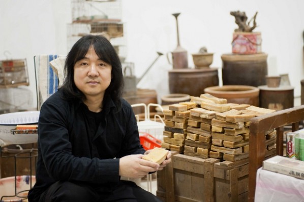 Chinese artist Song Dong poses with old bars of soap at his exhibition at the Barbican Gallery in London Song Dong Waste Not which ends June 12, 2012 Photographer Jane Hobson