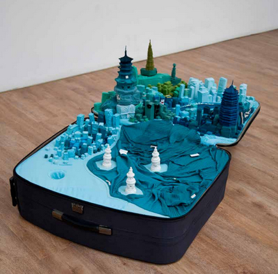 Yin Xiuzhen, Portable City–Hangzhou, 2011. Suitcase, clothes, magnifying glass, map, sound element, 11 x 59 1316 x 34 58. Courtesy of Pace Beijing. © Yin Xiuzhen. Yin Xiuzhen, Portable City–Hangzhou, 2011. Suitcase, clothes, magnifying glass, map, sound element, 11 x 59 1316 x 34 58. Courtesy of Pace Beijing. © Yin Xiuzhen.